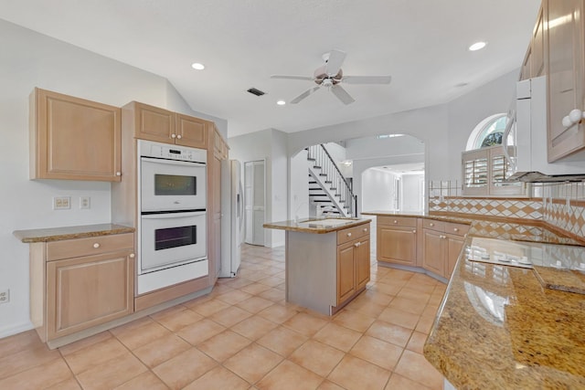 163 Pepper Ln, Jensen Beach, FL 34957 - kitchen featuring white appliances, light brown cabinets, ceiling fan, light stone countertops, and backsplash