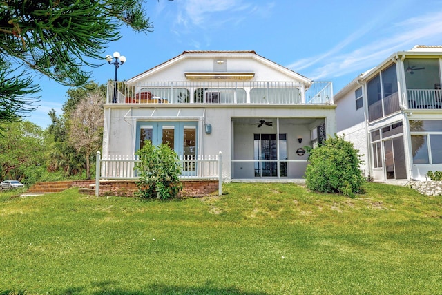 163 Pepper Ln, Jensen Beach, FL 34957 - back of house featuring a balcony, a sunroom, ceiling fan, stucco siding, and a lawn