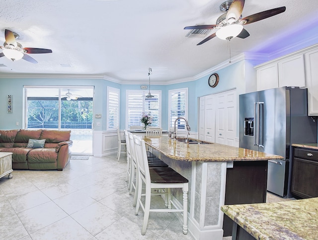 126 Hidden Hollow Dr, Palm Beach Gardens, FL 33418 - kitchen featuring high end fridge, a ceiling fan, light stone counters, crown molding, and a kitchen breakfast bar