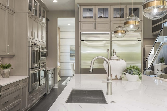 13405 Artisan Cir, Palm Beach Gardens, FL 33418 - kitchen with built in refrigerator, glass insert cabinets, light stone countertops, stainless steel double oven, and recessed lighting