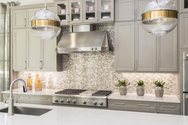 13405 Artisan Cir, Palm Beach Gardens, FL 33418 - kitchen featuring wall chimney exhaust hood, gray cabinetry, glass insert cabinets, and tasteful backsplash