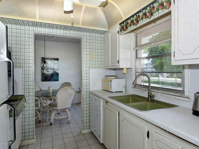 2 Golfs Edge Unit F, West Palm Beach, FL 33417 - kitchen with white appliances, light tile patterned floors, light countertops, white cabinetry, and wallpapered walls