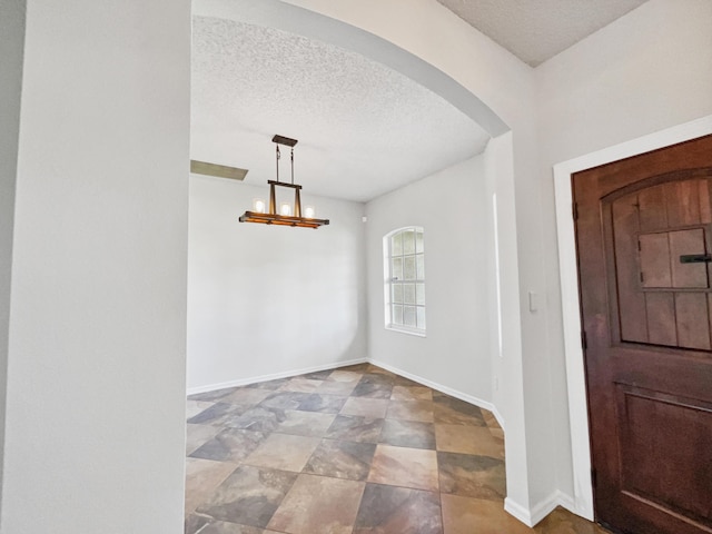 2081 SW Burlington St, Port Saint Lucie, FL 34984 - entryway with a textured ceiling, arched walkways, and a chandelier