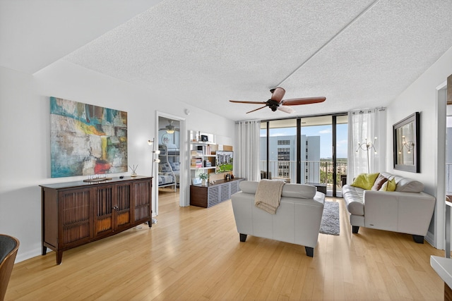 336 Golfview Rd Unit 1006, North Palm Beach, FL 33408 - living area with a ceiling fan, a textured ceiling, expansive windows, and light wood-style floors