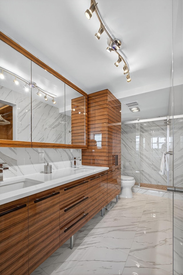 336 Golfview Rd Unit 1006, North Palm Beach, FL 33408 - bathroom featuring double vanity, marble finish floors, tile walls, a marble finish shower, and rail lighting