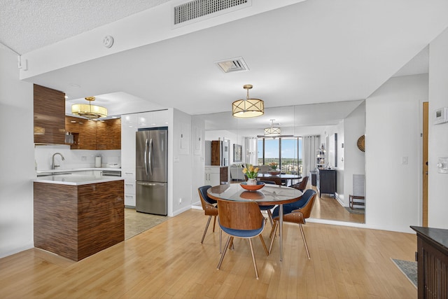 336 Golfview Rd Unit 1006, North Palm Beach, FL 33408 - dining room with light wood-style flooring and a chandelier