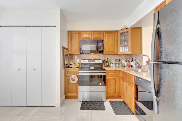 14723 Cumberland Dr Unit 404B, Delray Beach, FL 33446 - kitchen featuring black appliances, backsplash, glass insert cabinets, light stone countertops, and light tile patterned floors