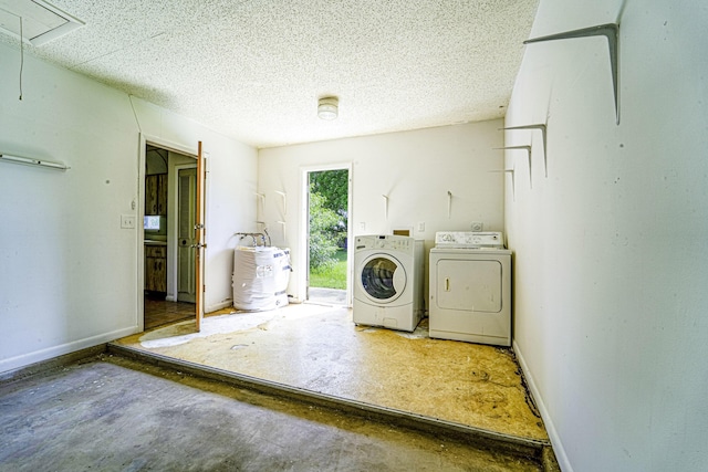 washroom with separate washer and dryer, attic access, and a textured ceiling