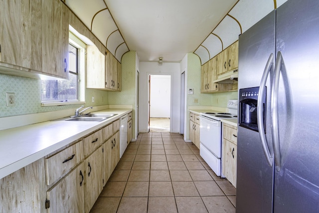 kitchen with white appliances, under cabinet range hood, and light brown cabinets