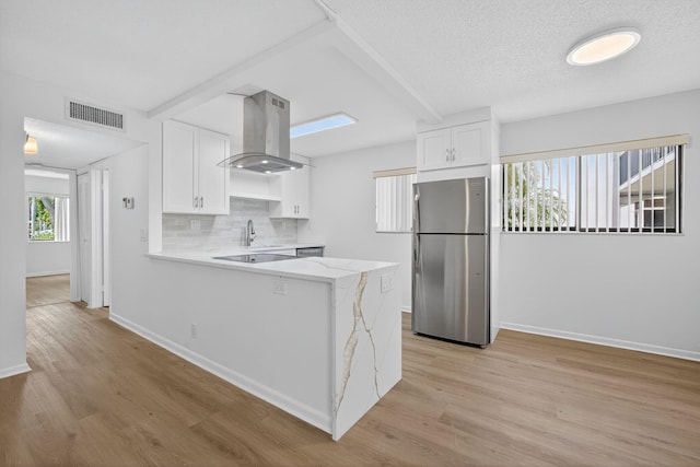 15036 Ashland Ln Unit 44, Delray Beach, FL 33484 - kitchen with stainless steel appliances, island range hood, white cabinetry, light wood finished floors, and a textured ceiling