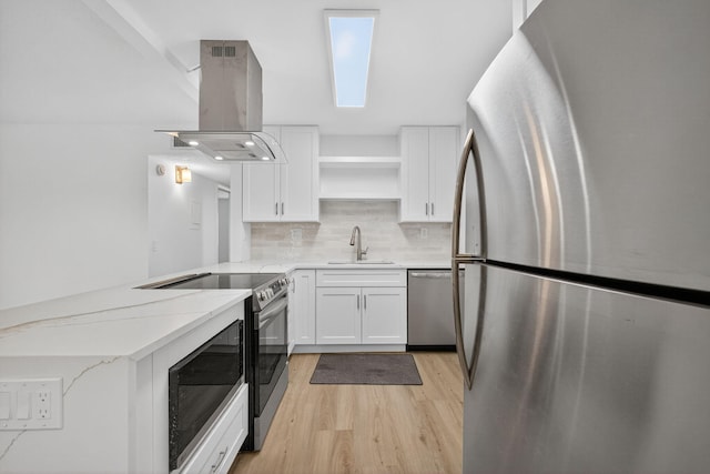 15036 Ashland Ln Unit 44, Delray Beach, FL 33484 - kitchen featuring appliances with stainless steel finishes, island range hood, open shelves, a peninsula, and light wood-style flooring