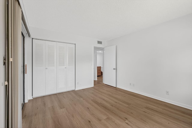 15036 Ashland Ln Unit 44, Delray Beach, FL 33484 - unfurnished bedroom featuring light wood-type flooring, a closet, and a textured ceiling