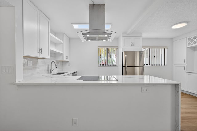 15036 Ashland Ln Unit 44, Delray Beach, FL 33484 - kitchen featuring freestanding refrigerator, island exhaust hood, black electric stovetop, open shelves, and light wood finished floors