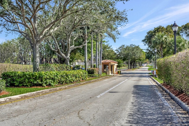 15036 Ashland Ln Unit 44, Delray Beach, FL 33484 - view of asphalt road featuring street lighting, curbs, and a gated entry
