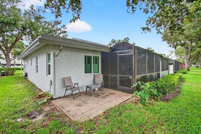 18541 Cherborg Dr Unit D, Boca Raton, FL 33496 - back of property featuring stucco siding, a sunroom, a patio area, and a yard