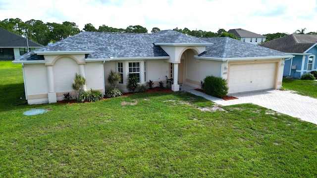 5705 NW Crocus Ave, Port Saint Lucie, FL 34986 - ranch-style house with an attached garage, decorative driveway, stucco siding, a shingled roof, and a front lawn