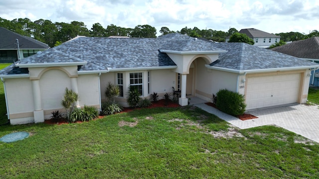 5705 NW Crocus Ave, Port Saint Lucie, FL 34986 - view of front of property with stucco siding, an attached garage, a shingled roof, a front yard, and driveway