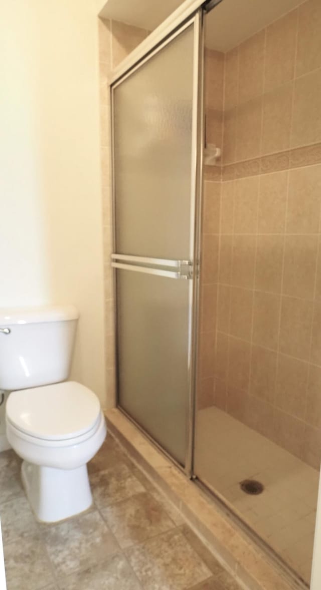 5705 NW Crocus Ave, Port Saint Lucie, FL 34986 - bathroom featuring a stall shower and toilet