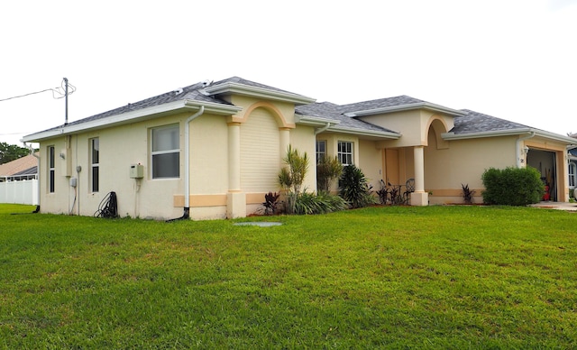 5705 NW Crocus Ave, Port Saint Lucie, FL 34986 - view of home's exterior featuring stucco siding, a yard, and an attached garage