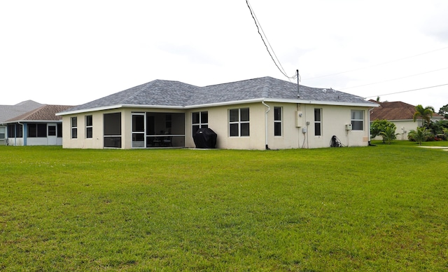 5705 NW Crocus Ave, Port Saint Lucie, FL 34986 - rear view of property featuring a lawn, stucco siding, a sunroom, and roof with shingles