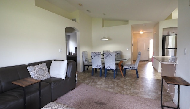 5705 NW Crocus Ave, Port Saint Lucie, FL 34986 - living room with arched walkways, stone finish floors, and high vaulted ceiling