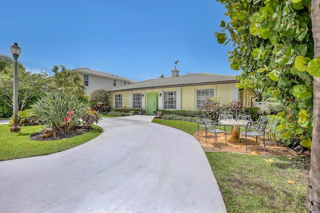 219 Claremont Ln, Palm Beach Shores, FL 33404 - ranch-style house with stucco siding, a chimney, a tiled roof, a patio, and a front yard