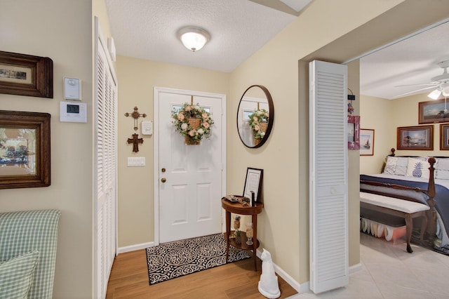 5707 Parkwalk Cir E, Boynton Beach, FL 33472 - foyer entrance featuring ceiling fan, light wood-style floors, and a textured ceiling