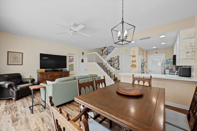 11 Live Oak Cir Unit 11, Tequesta, FL 33469 - dining room with stairway, light wood-type flooring, ceiling fan, and a chandelier