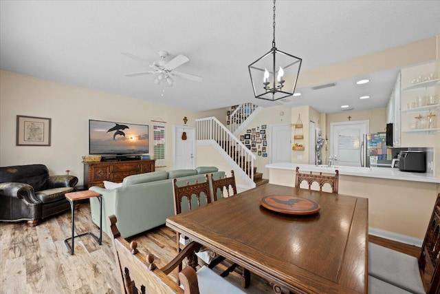11 Live Oak Cir Unit 11, Tequesta, FL 33469 - dining space with stairway, light wood finished floors, a ceiling fan, a chandelier, and recessed lighting
