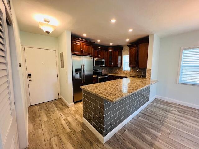 1120 99th St Unit 301, Bay Harbor Islands, FL 33154 - kitchen with stainless steel appliances, a peninsula, light wood finished floors, light stone countertops, and recessed lighting