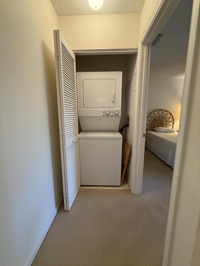 1142 Keystone Dr Unit C, Jupiter, FL 33458 - laundry area featuring stacked washing machine and dryer, carpet, and a textured ceiling