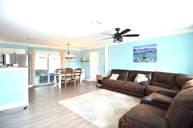 5447 SE 51st Dr, Stuart, FL 34997 - living room featuring ornamental molding, light wood finished floors, a ceiling fan, and a chandelier