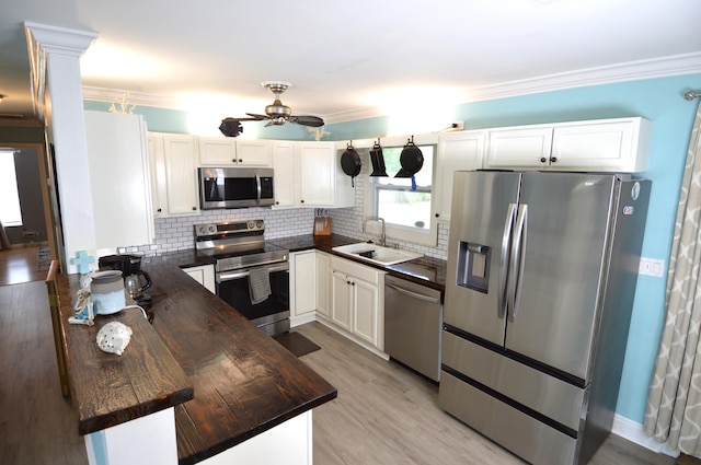 5447 SE 51st Dr, Stuart, FL 34997 - kitchen with appliances with stainless steel finishes, ceiling fan, tasteful backsplash, white cabinets, and crown molding
