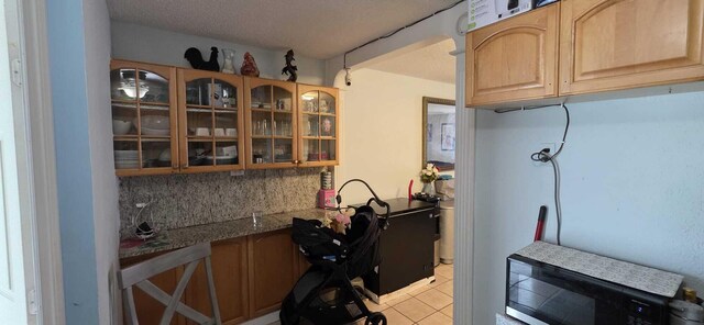 4732 Chariot Cir, Greenacres, FL 33463 - kitchen featuring black microwave, glass insert cabinets, decorative backsplash, light tile patterned floors, and light brown cabinetry