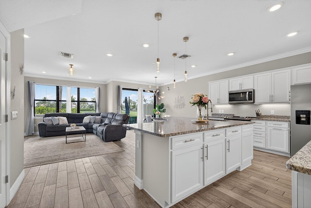 8343 Cinch Way, Lake Worth, FL 33467 - kitchen featuring appliances with stainless steel finishes, light wood finished floors, light stone counters, white cabinetry, and ornamental molding
