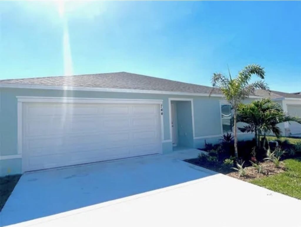 744 SE 25th Dr, Okeechobee, FL 34974 - ranch-style house with a garage, driveway, and stucco siding