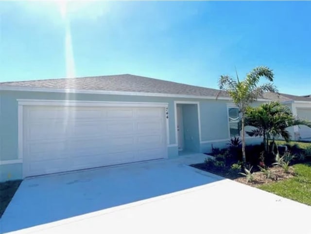 744 SE 25th Dr, Okeechobee, FL 34974 - ranch-style house with a garage, driveway, and stucco siding