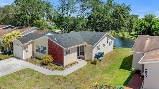 9890 W Heather Ln, Miramar, FL 33025 - view of front of home with driveway, an attached garage, a front lawn, roof with shingles, and a water view