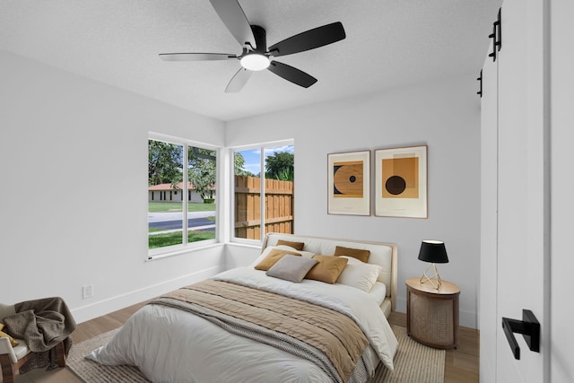 21436 Woodchuck Ln, Boca Raton, FL 33428 - bedroom with wood finished floors, a barn door, and ceiling fan