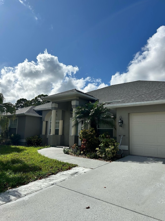 1701 SW Penrose Ave, Port Saint Lucie, FL 34953 - view of front facade featuring stucco siding, an attached garage, and concrete driveway