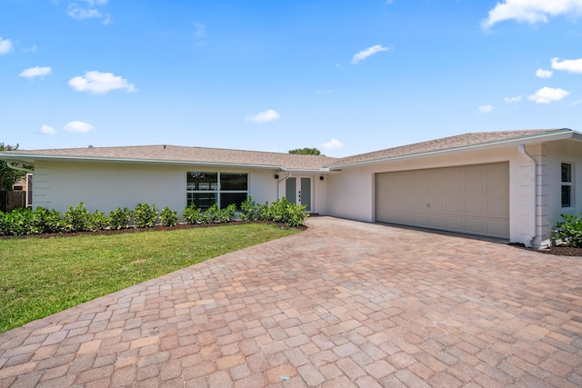 77 Fairview E, Tequesta, FL 33469 - single story home with stucco siding, decorative driveway, a garage, and a front lawn