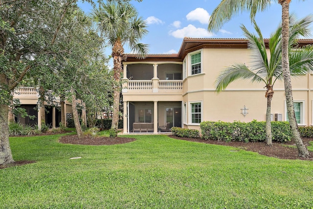 171 Tresana Blvd Unit 129, Jupiter, FL 33478 - back of house with stucco siding, a sunroom, a lawn, and a balcony