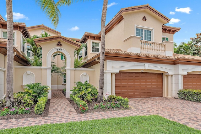 171 Tresana Blvd Unit 129, Jupiter, FL 33478 - mediterranean / spanish home with decorative driveway, a tile roof, an attached garage, stucco siding, and a balcony