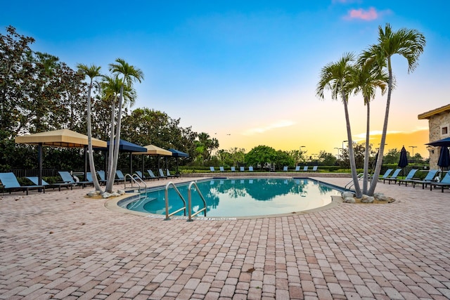 171 Tresana Blvd Unit 129, Jupiter, FL 33478 - pool at dusk with a patio and a community pool