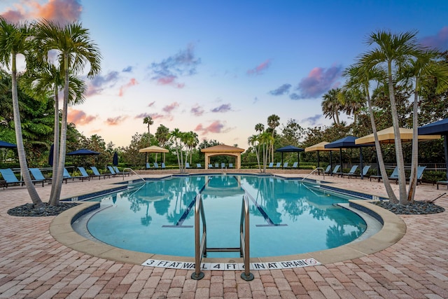 171 Tresana Blvd Unit 129, Jupiter, FL 33478 - pool at dusk featuring a gazebo, a community pool, and a patio area