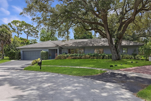 6532 Serena Ln, Boca Raton, FL 33433 - ranch-style house featuring asphalt driveway, a tile roof, an attached garage, and a front lawn