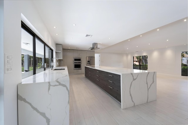 6532 Serena Ln, Boca Raton, FL 33433 - kitchen featuring modern cabinets, high end fridge, wall chimney exhaust hood, a large island, and recessed lighting
