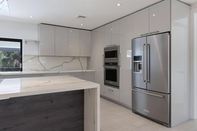 6532 Serena Ln, Boca Raton, FL 33433 - kitchen featuring appliances with stainless steel finishes, modern cabinets, backsplash, light stone countertops, and gray cabinets