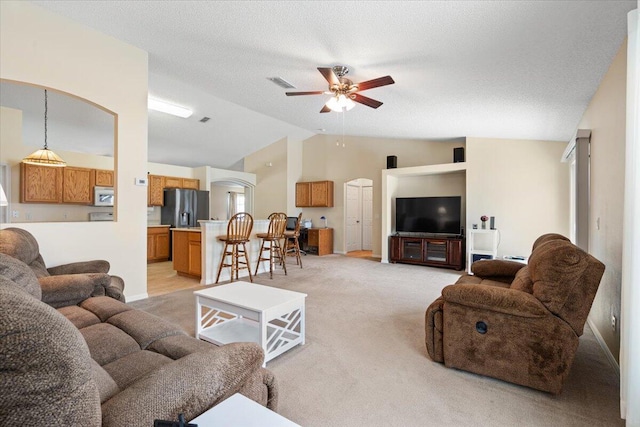 516 SW Crawfish Dr, Port Saint Lucie, FL 34953 - living room with lofted ceiling, light colored carpet, a ceiling fan, arched walkways, and a textured ceiling
