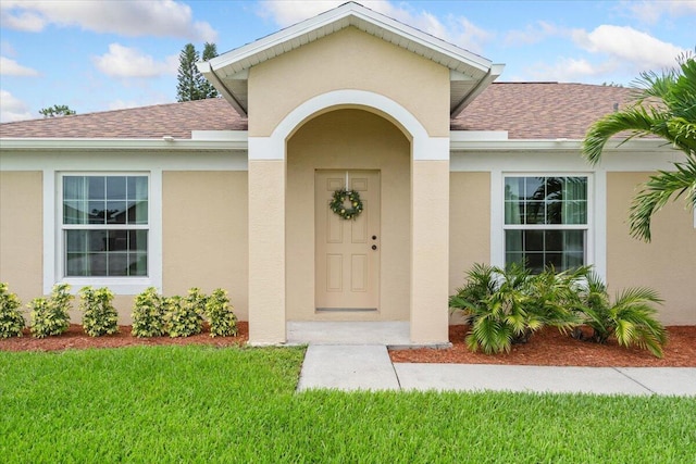 516 SW Crawfish Dr, Port Saint Lucie, FL 34953 - entrance to property with a shingled roof, stucco siding, and a yard